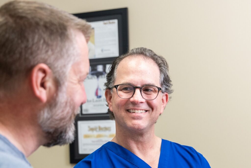 Dr. Cernero smiles at a patient during their consultation regarding the patient's diverticulitis near Dallas.